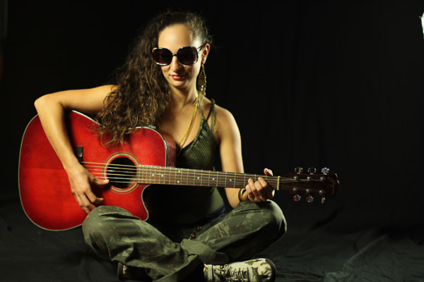 Auresia sitting with red guitar